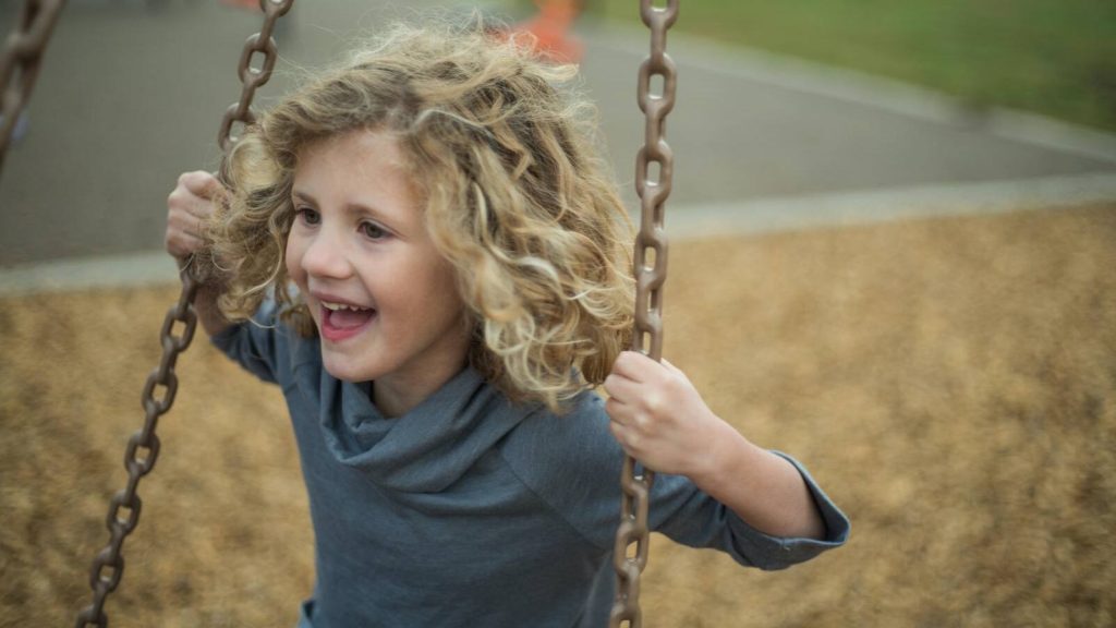 Girl on a swing, in a park