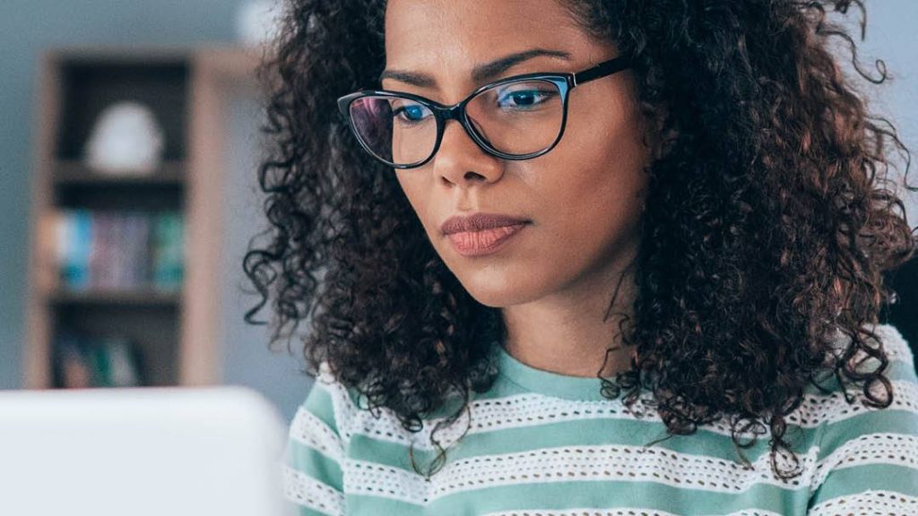 a young Black woman wearing blue light-blocking glasses