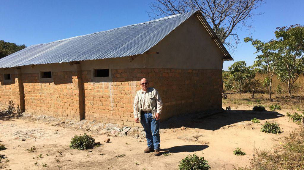 Kenneth Hobby stands in front of a church he helped to build in Zambia in southern Africa.