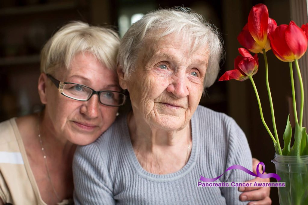 a portrait of two women, one elderly, the other middle age, perhaps a mother and daughter with a purple Pancreatic Cancer Awareness ribbon graphic