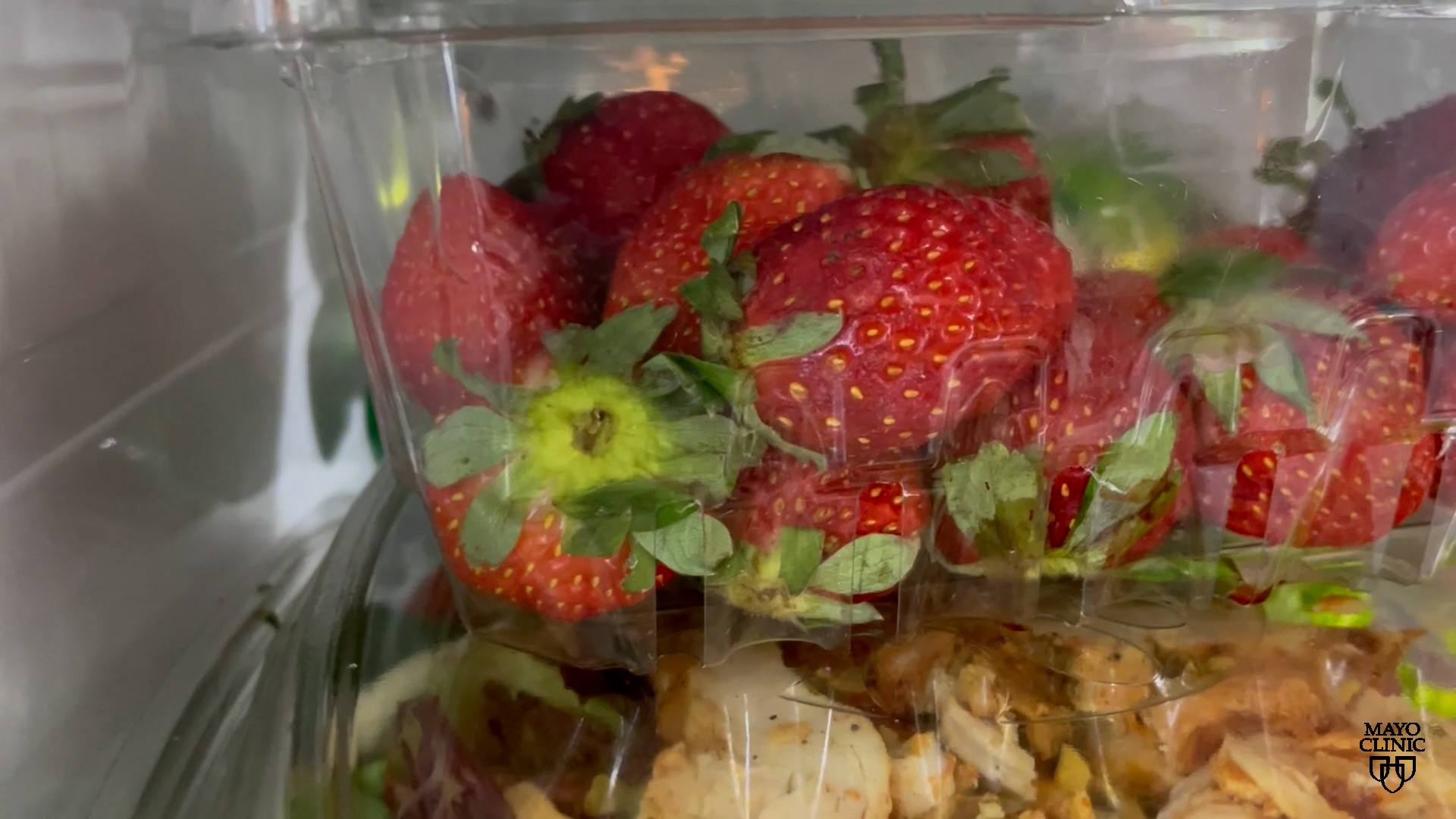 Moldy strawberries in a container in the fridge.