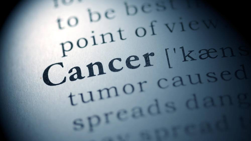 a close-up of the word 'Cancer' with a partial definition, styled to look like a dictionary entry