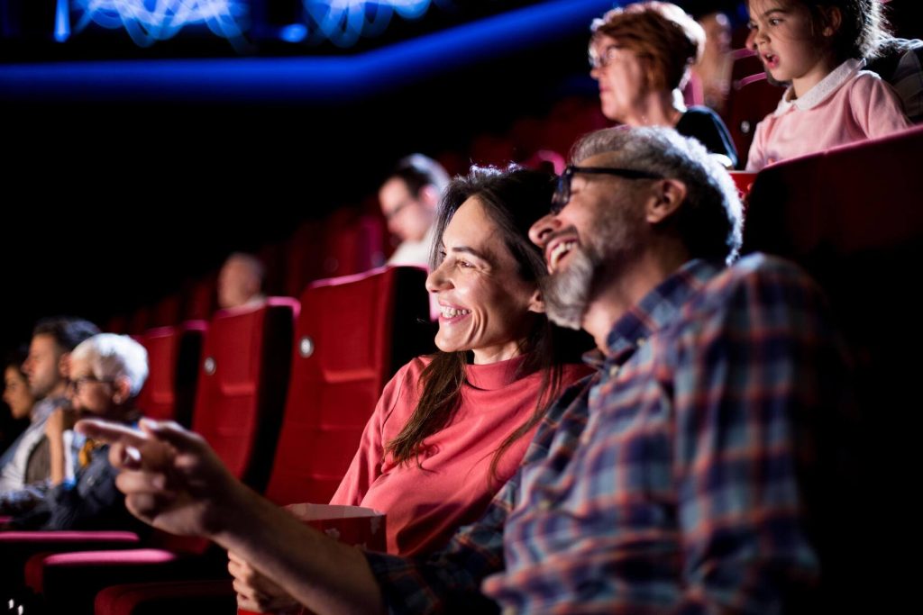 a man and a woman laughing together in a movie theatre
