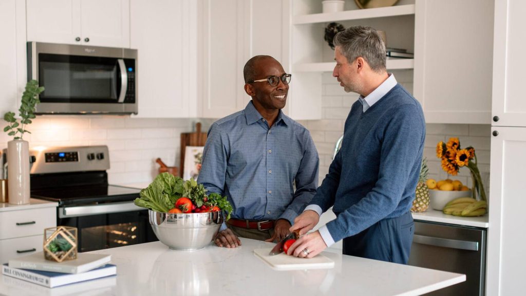 Two men in kitchen with vegetables, male couple, diversity, LGBTQ