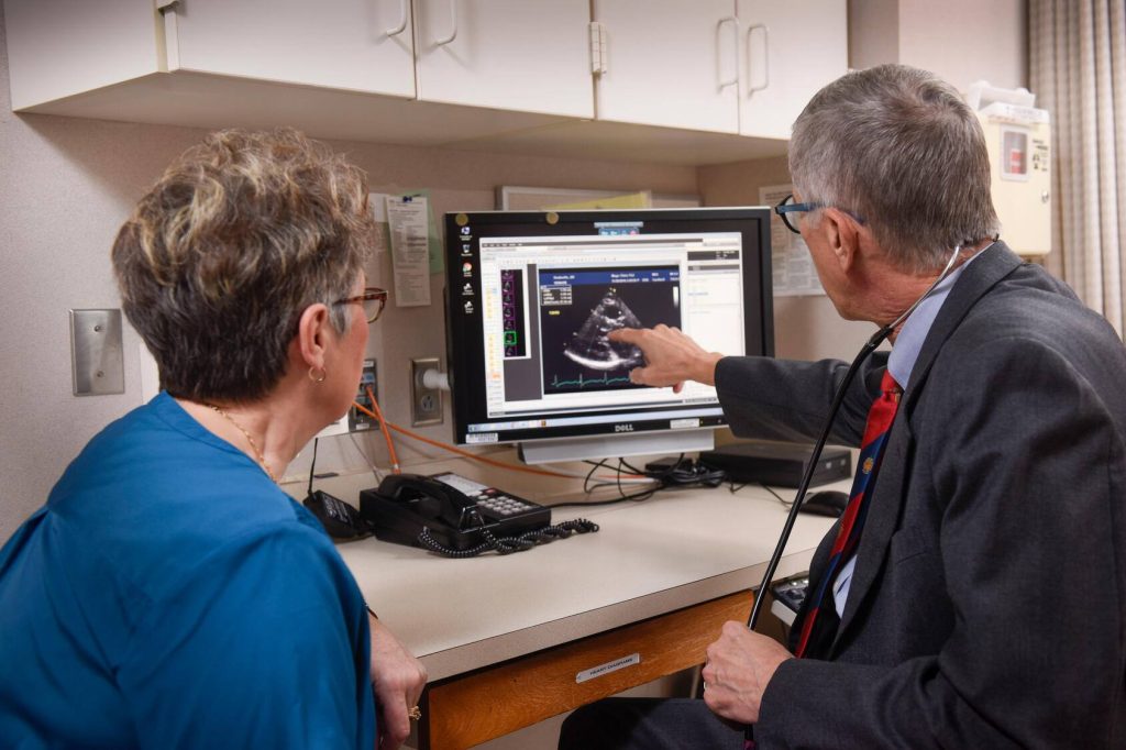 Dr. Hartzell Schaff showing patient an image of a heart on a computer screen