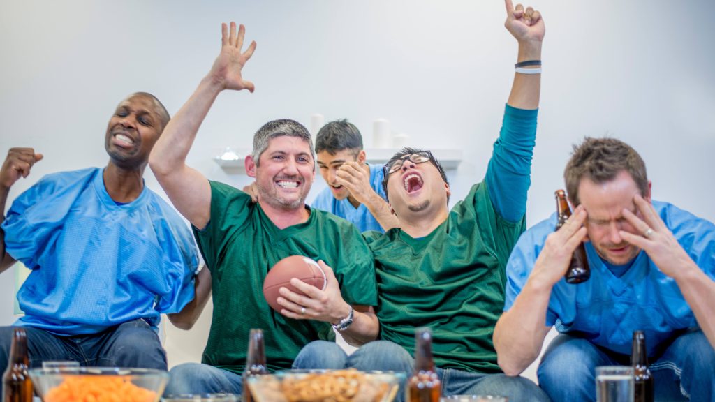 Group of men cheering on a football game