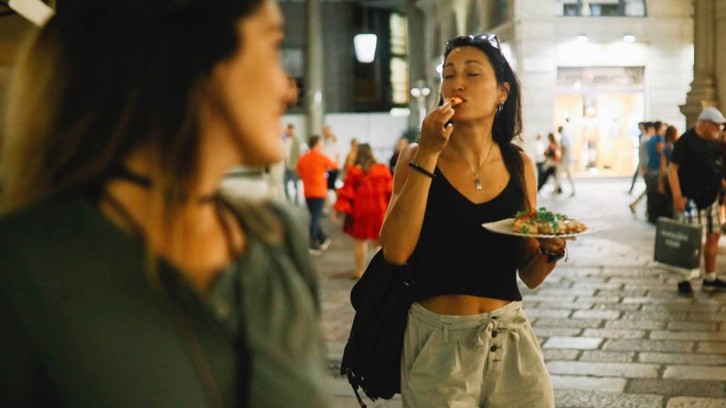woman eating street food while traveling