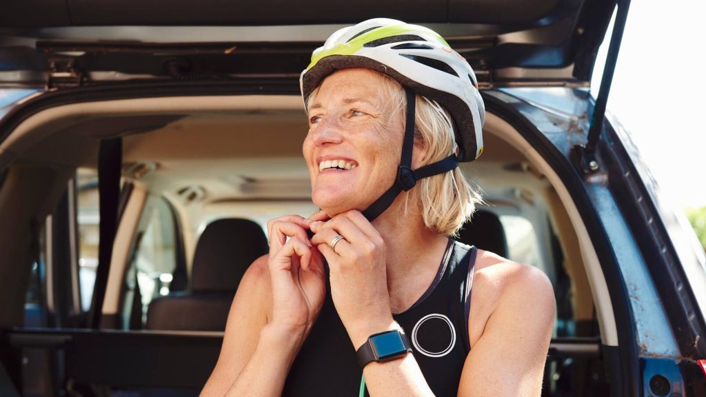 woman adjusts bike helmet, bicycle, safety