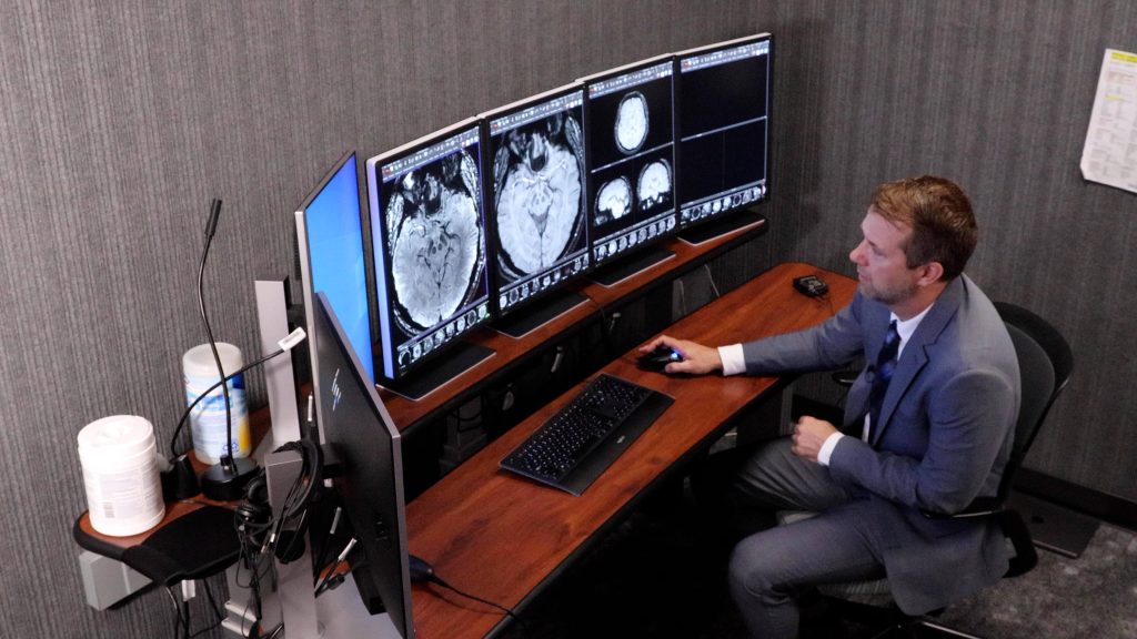 Justin Cramer, M.D. reviews brain scans. He is comparing scans from 7-Tesla and other imaging tools.
