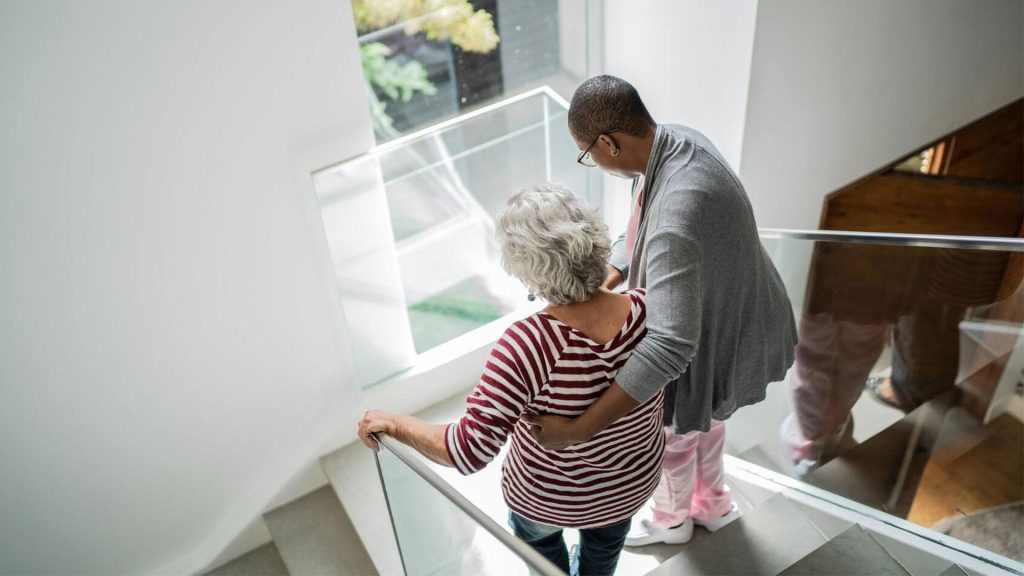 Nurse helping woman down stairs