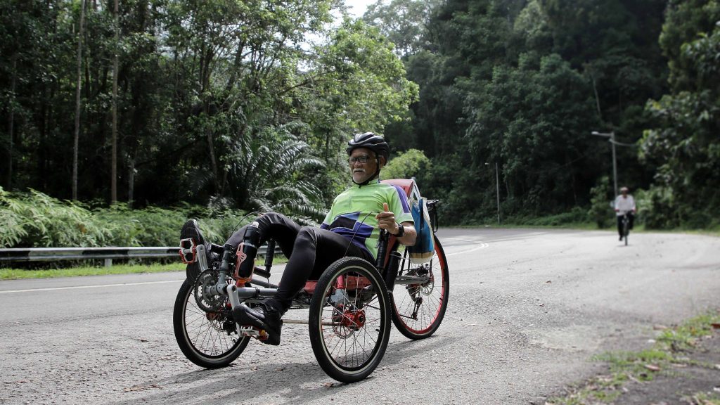 Man on recumbent bike, bicyle, wearing helmet, diversity, older African American/Black male, riding bike, Getty Images