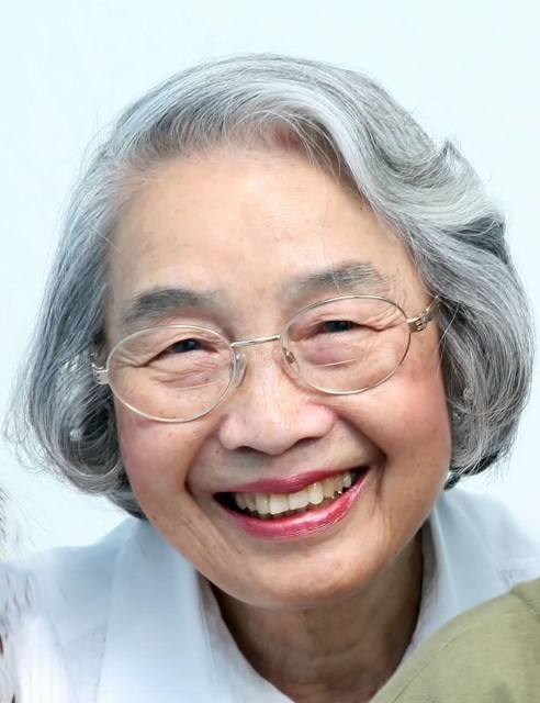 A smiling older woman with glasses.