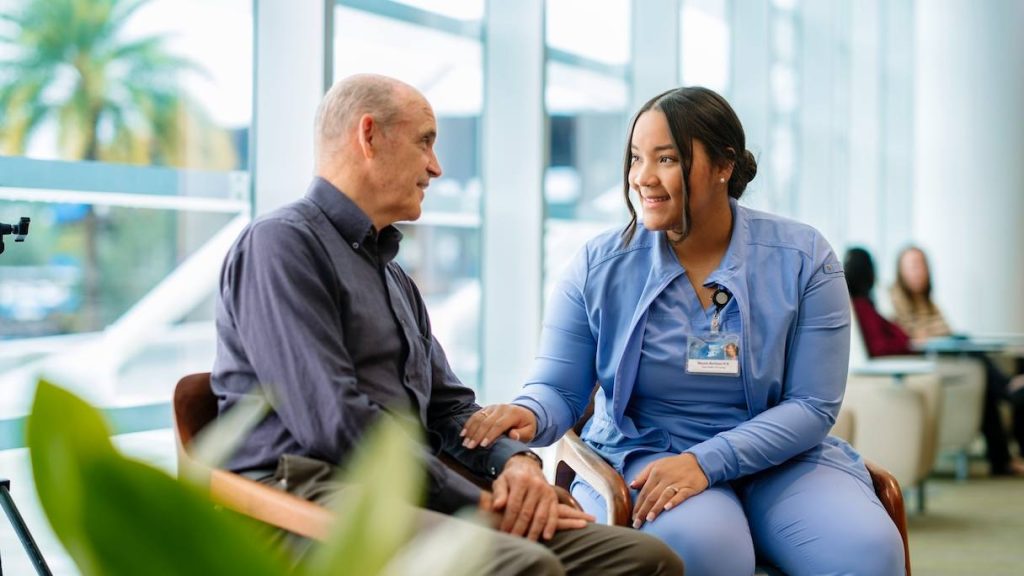 Older man sittng with Mayo Clinic nurse, talking, patient experience