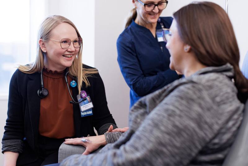 Physician assistant and nurse tend to chemotherapy patient, immunotherapy