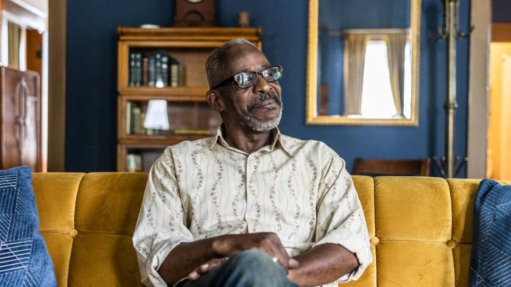 Portrait of an older, senior male, man sitting on a couch at home
