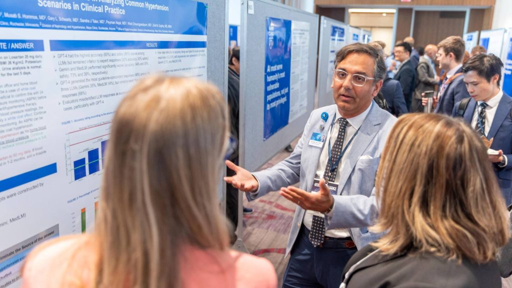 Researcher explains work to attendees at AI Summit poster session