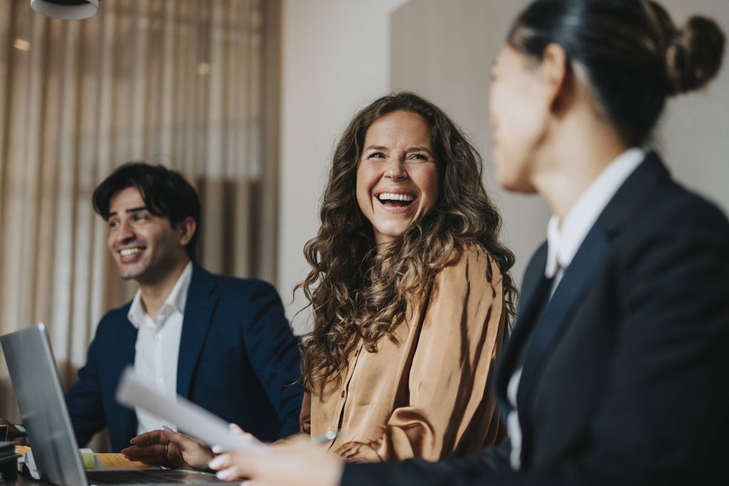 Smiling businesswoman speaking with colleagues