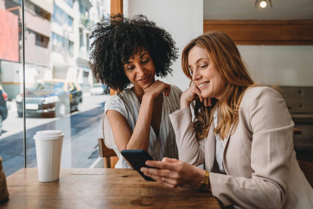 Women look at cellphone in cafe