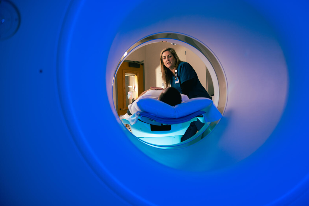 A technologist prepares a patient for a CT scan