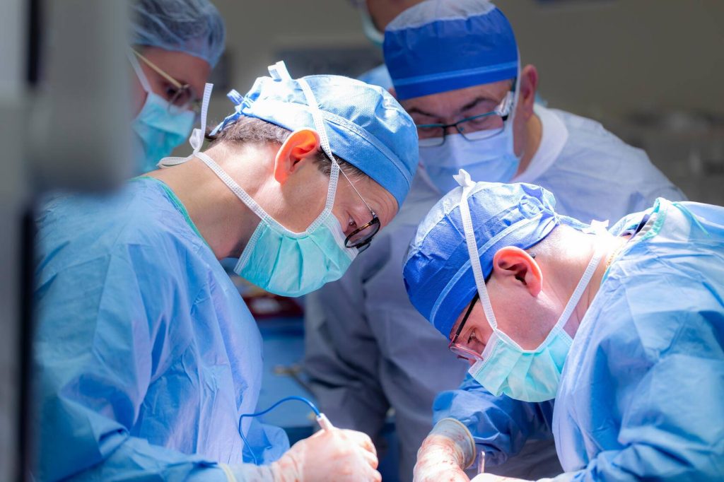 Dr. Patrick Starlinger and Dr. Timucin Taner are shown during a surgical operation.