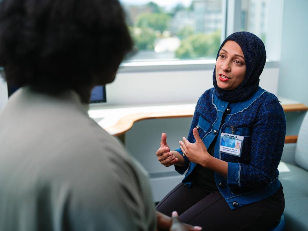 Female physician speaking with female patient in exam room