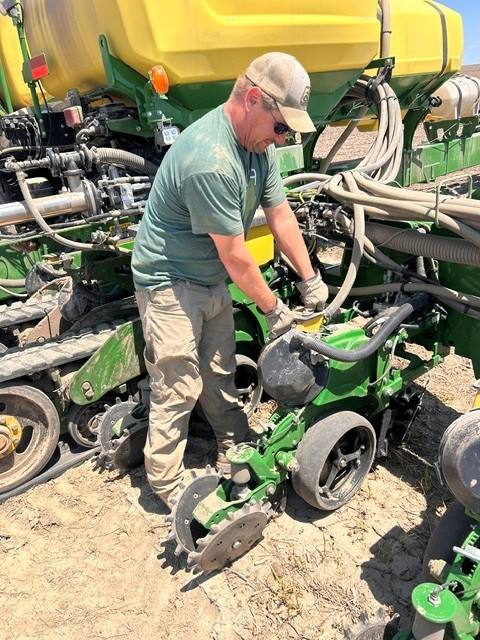 Chad works on planting equipment at his farm. Photo courtesy of Chad Rockow.