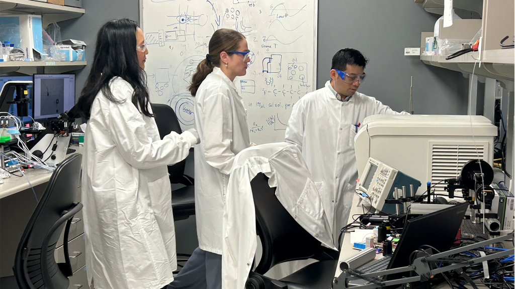 Connie Chang, Ph.D., and two research team members work with equipment in a Mayo Clinic engineering lab.