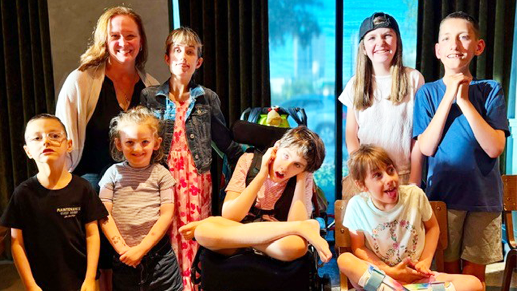 Margot Cousin, Ph.D., top left, with children with KCNK9 imprinting syndrome during a July symposium in Dallas. Pictured are Cole McCarthy, Inara Abel, Preston Kelley, Acadia Jenkins, Summer Nagele, Gracie Keeter and Mason Thomas.