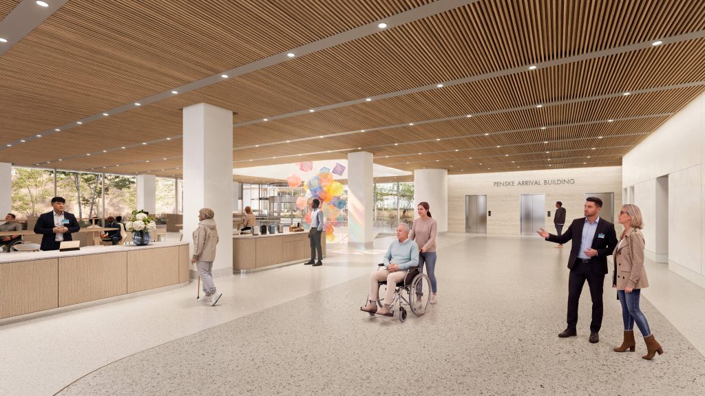 Rendering of the spacious Penske Arrival Building lobby with a wood-slat ceiling, reception desk, colorful art installation, elevators, and people moving through the space.