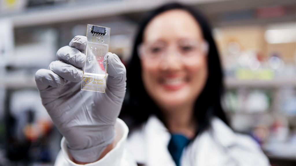 Connie Chang, Ph.D., holds a microfluidic platform used in the team's indoor-air biosensor.