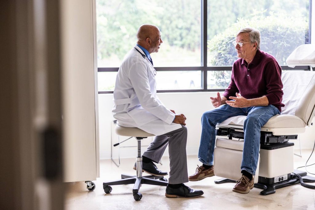 A physician and a patient speak in an exam room.