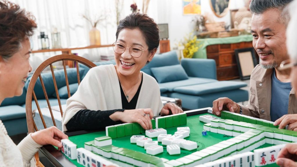 Felices amigos mayores jugando mahjong